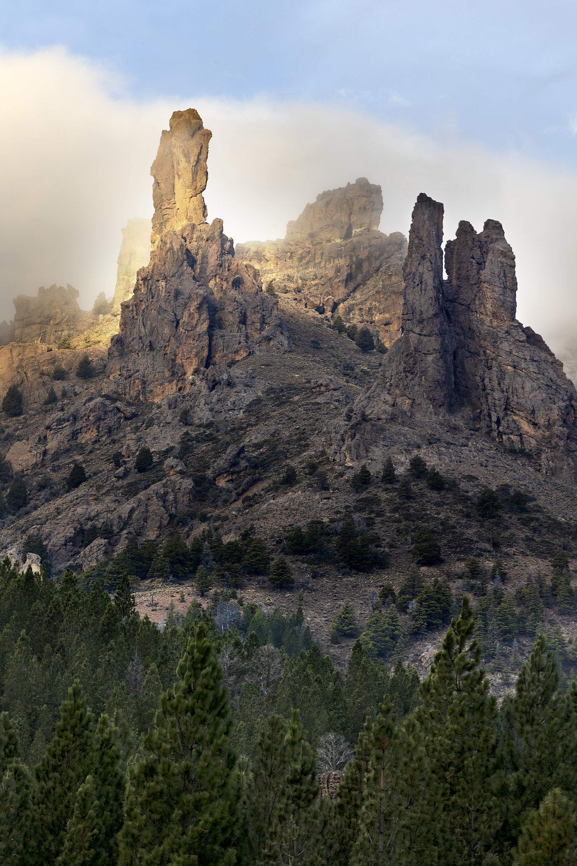 Tall rock spires/hoodoos against a clear sky in a desert-like environment. No people. The geological forms are the subject — landscape at scale.