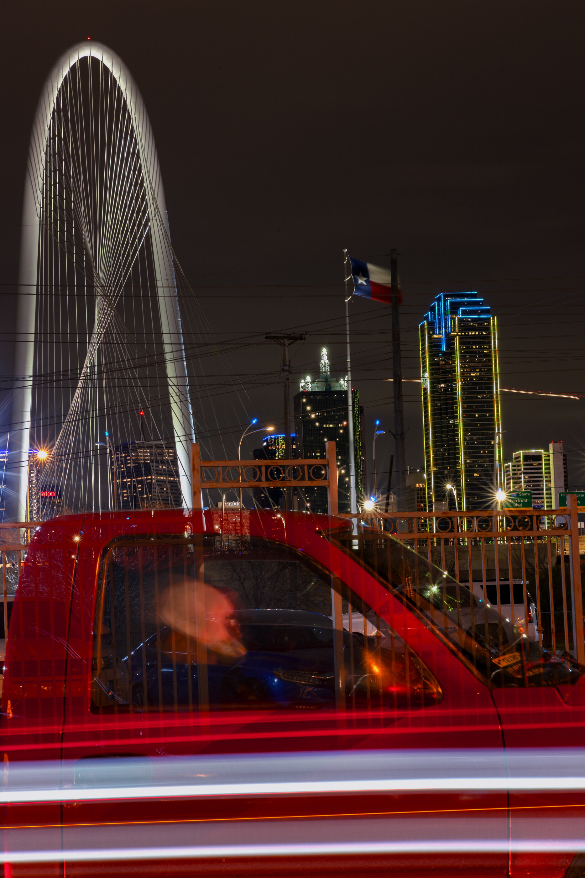 A red truck or vehicle photographed with strong motion blur against a colourful streaked background.
